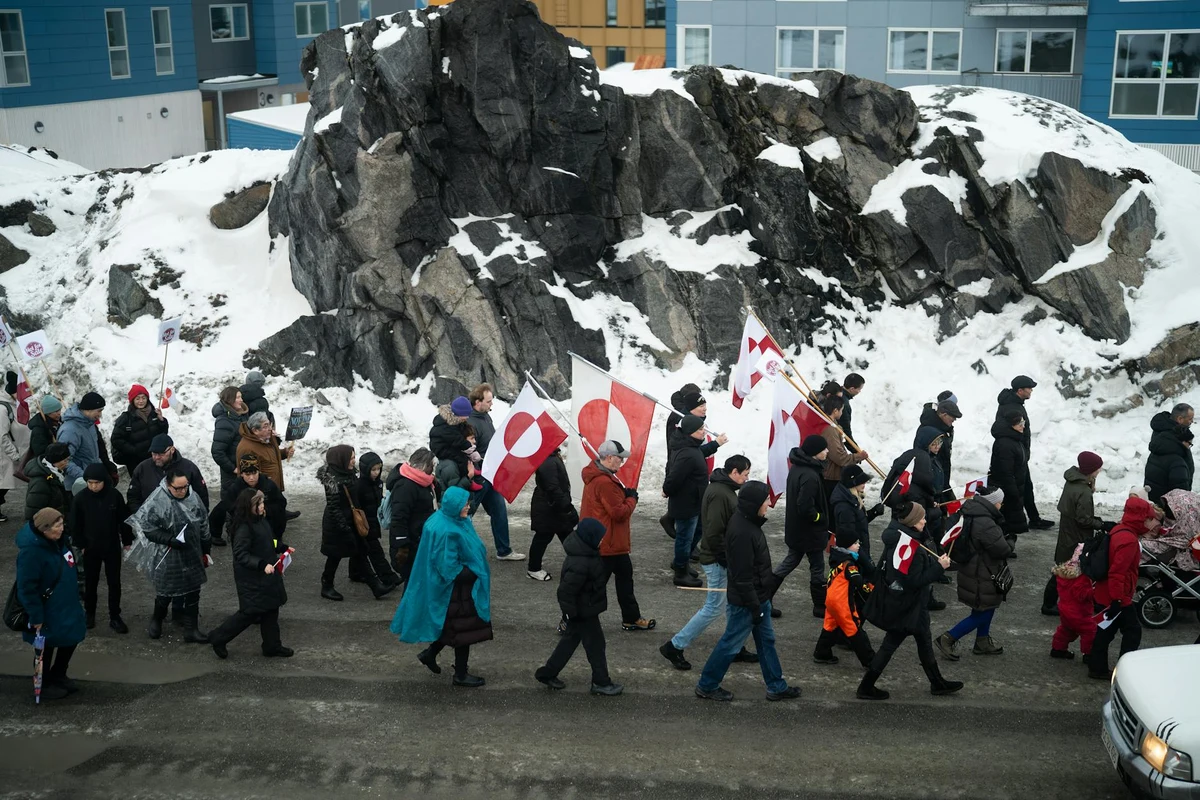 Марко Рубио, Мете Фредериксен и Йенс-Фредерик Нилсен по време на среща в кулоарите на Мюнхенската конференция по сигурността, с поставени знамена на САЩ, Дания и Гренландия на масата.