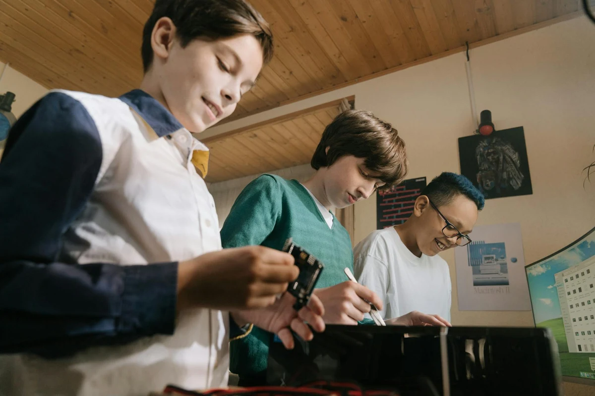 Деца на 9-10 години чакат с ученически карти пред компютърна зала в софийско училище за състезание по програмиране.