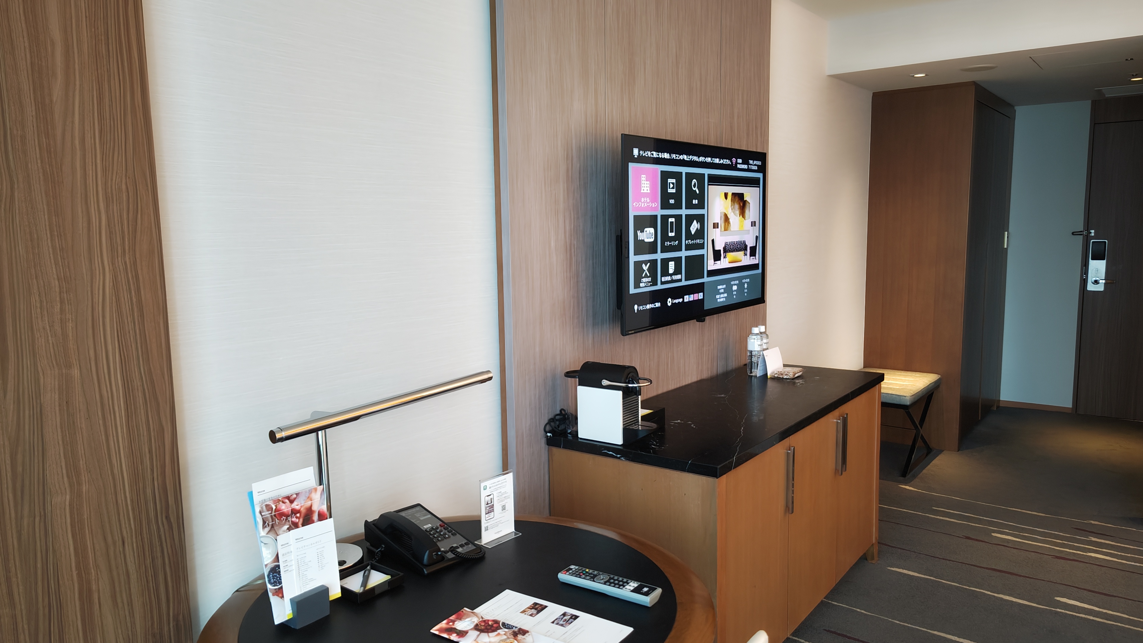 A television of the flat kind on the wall with a storage cabinet below