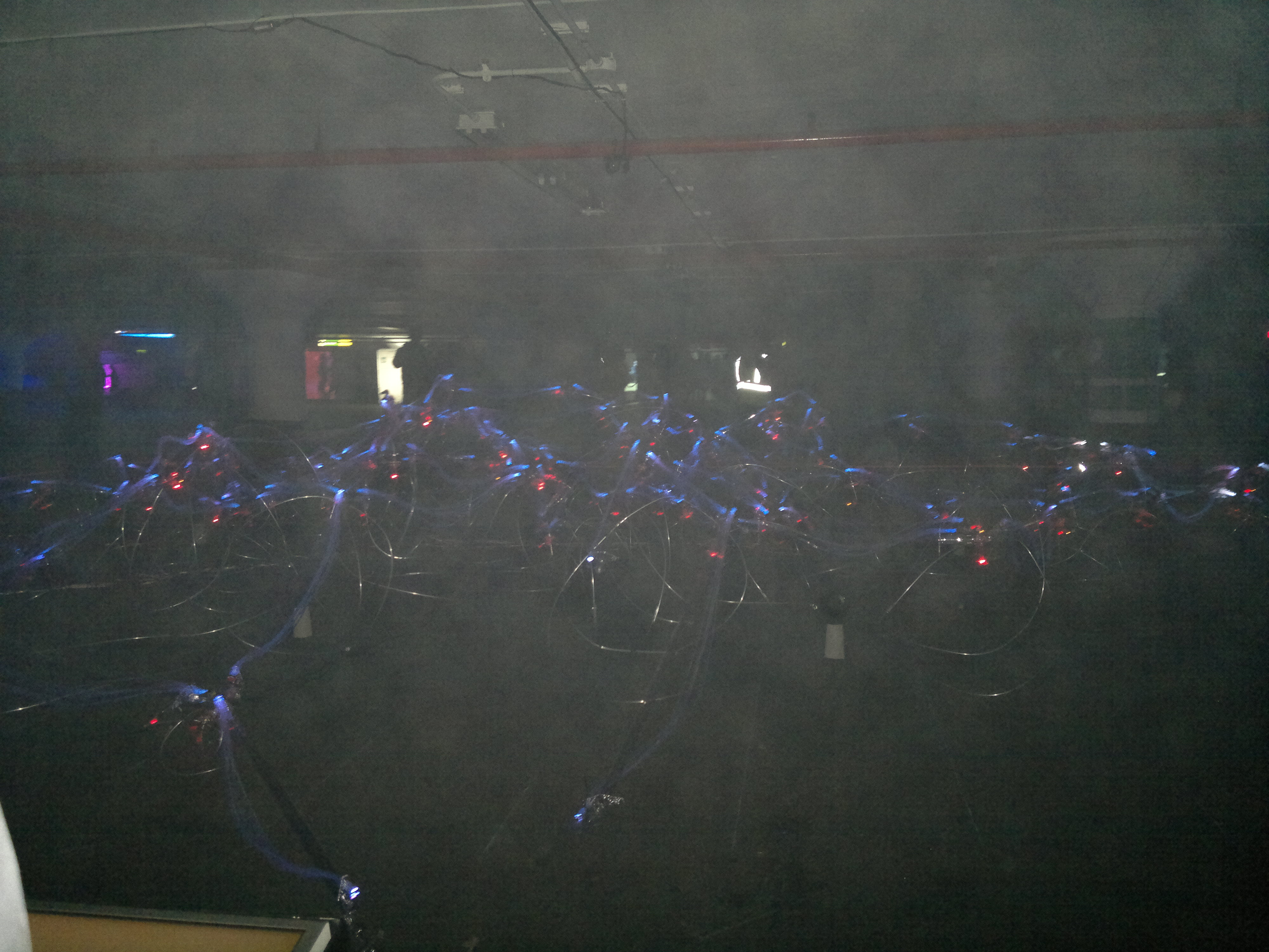 a smokey parking garage for nuit blanche with moving lights in it.