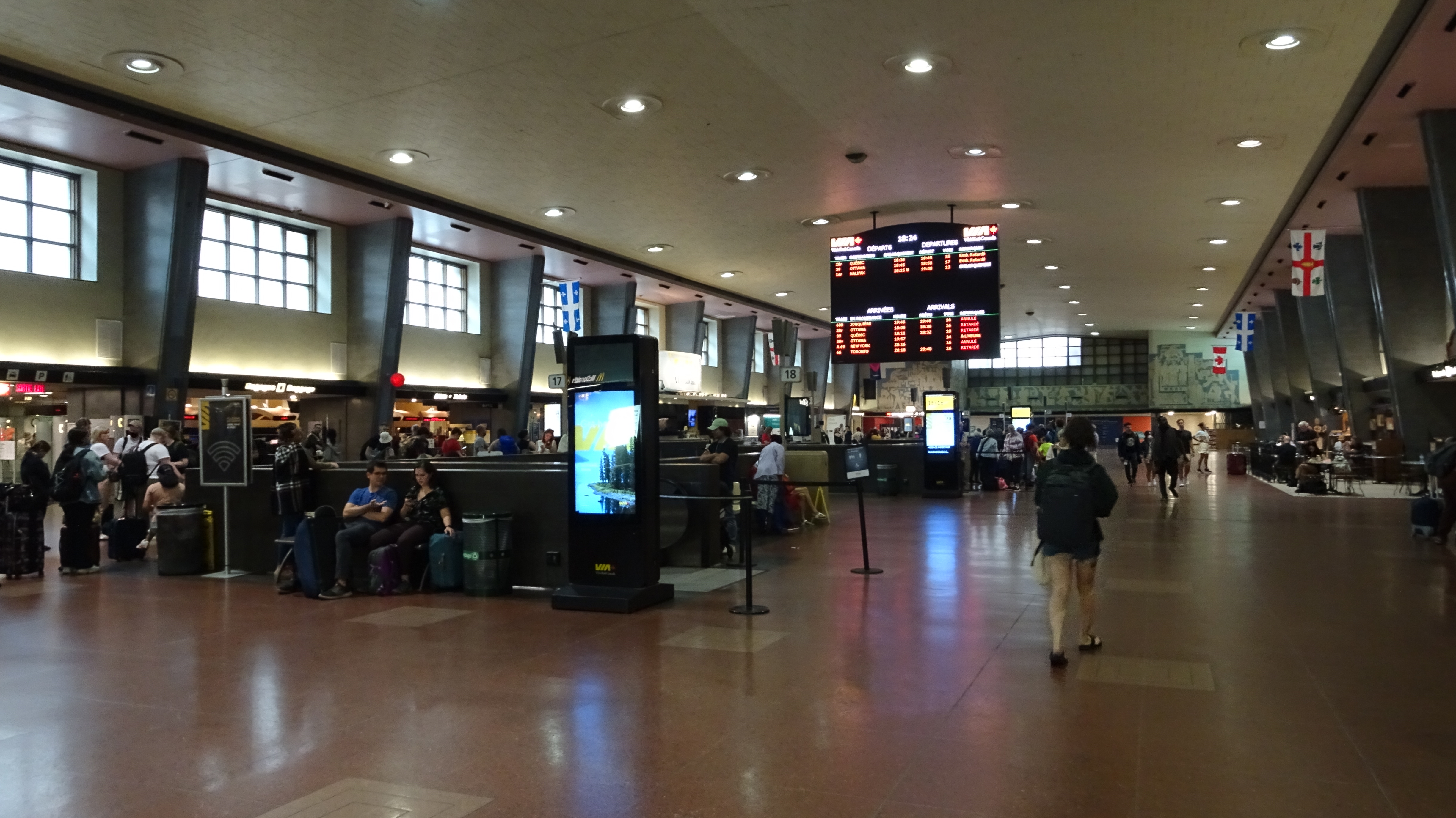 Passenger waiting area with large electronic display of arrivals and departures. Montreal Gare Centrale / Central Station.